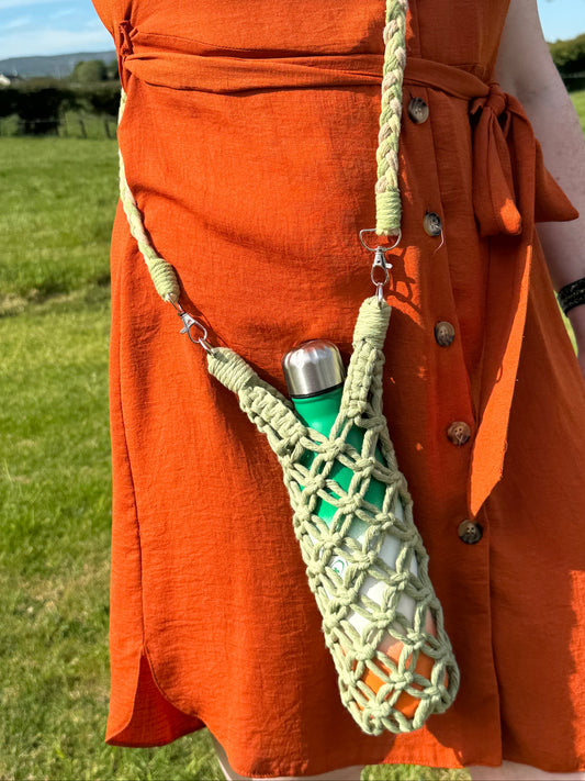 Person in an orange dress wearing a green macrame water bottle holder containing an irish flag bottle