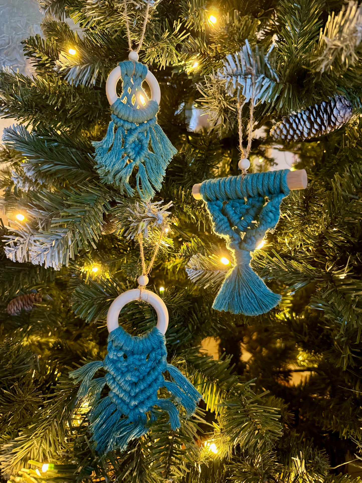 Decorative blue ornaments on a Christmas tree with lights.