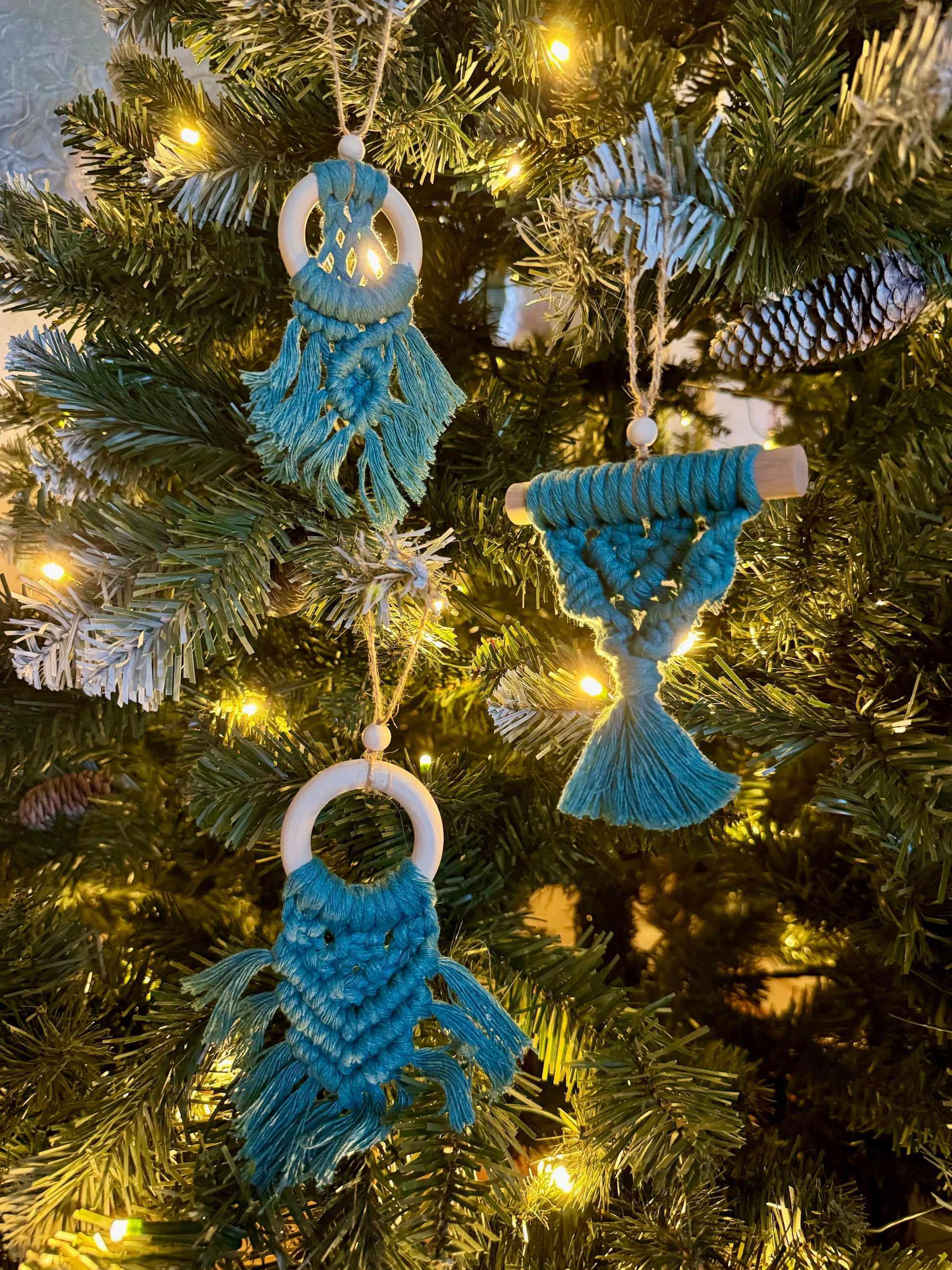 Decorative blue ornaments on a Christmas tree with lights.