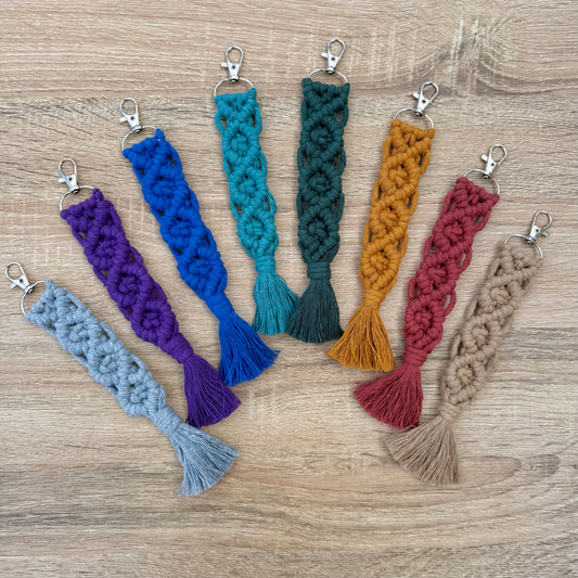 Set of colorful braided keychains on a wooden surface