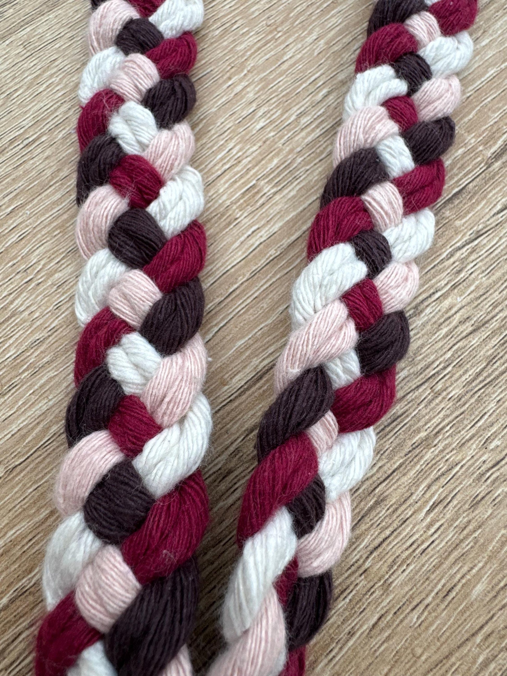 braided macrame cord with red, white, and brown colors on a wooden surface.