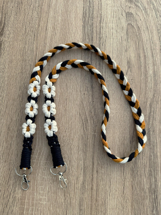 Braided bag strap with floral designs on a wooden surface