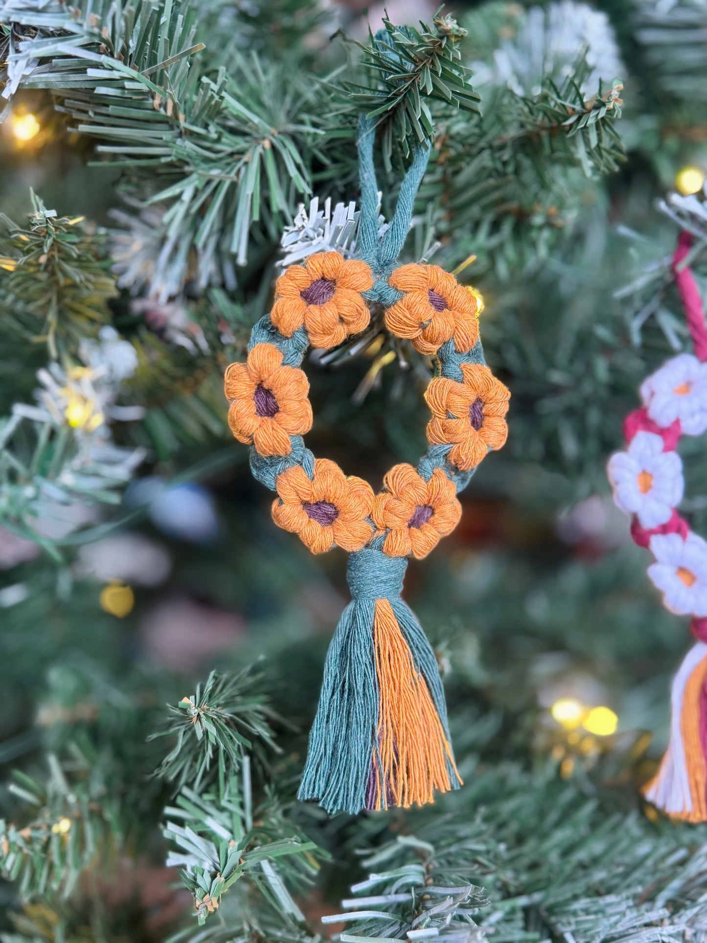 Decorative ornament with sunflowers and tassels on a Christmas tree.