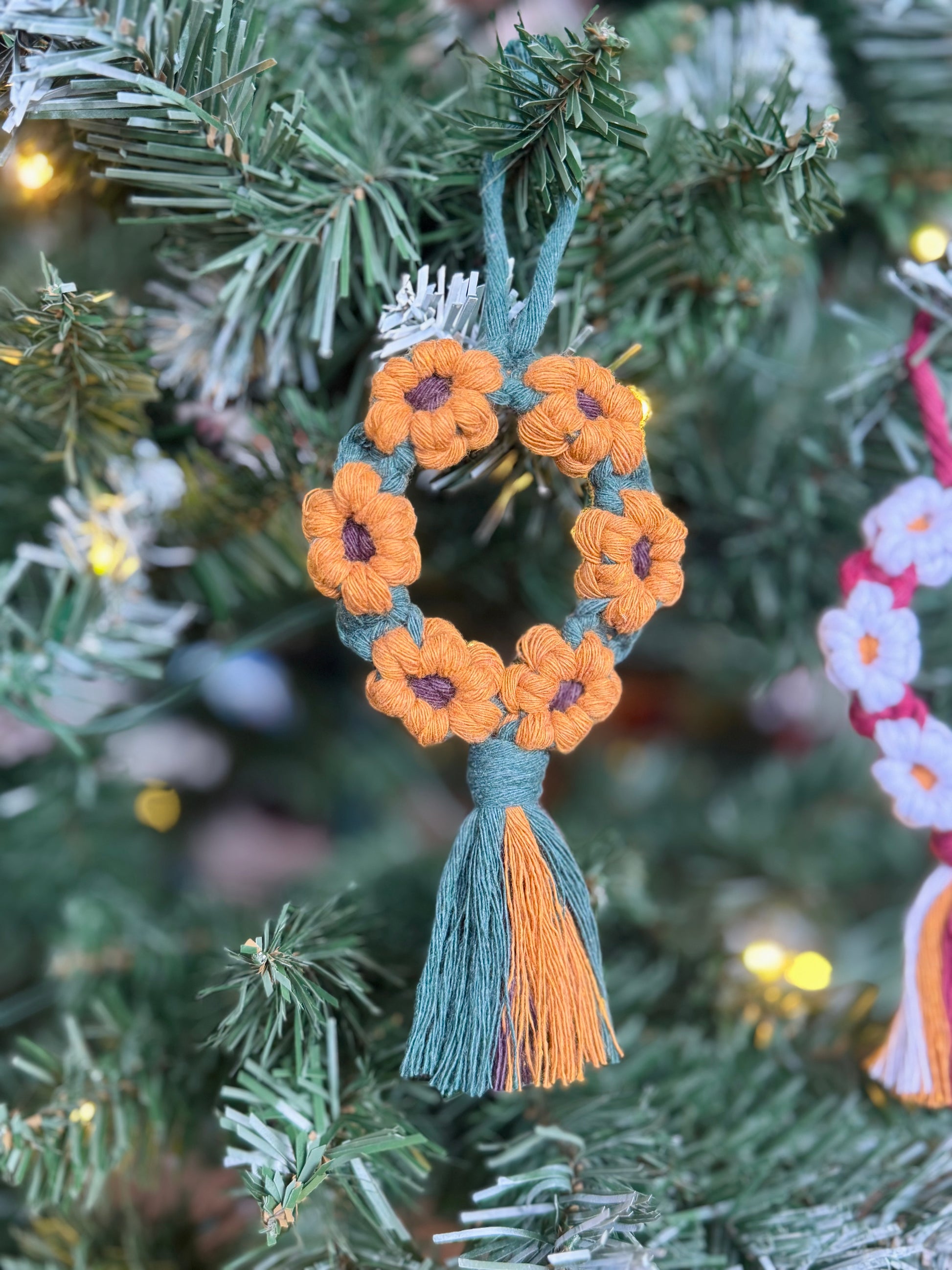 Decorative ornament with sunflowers and tassels on a Christmas tree.