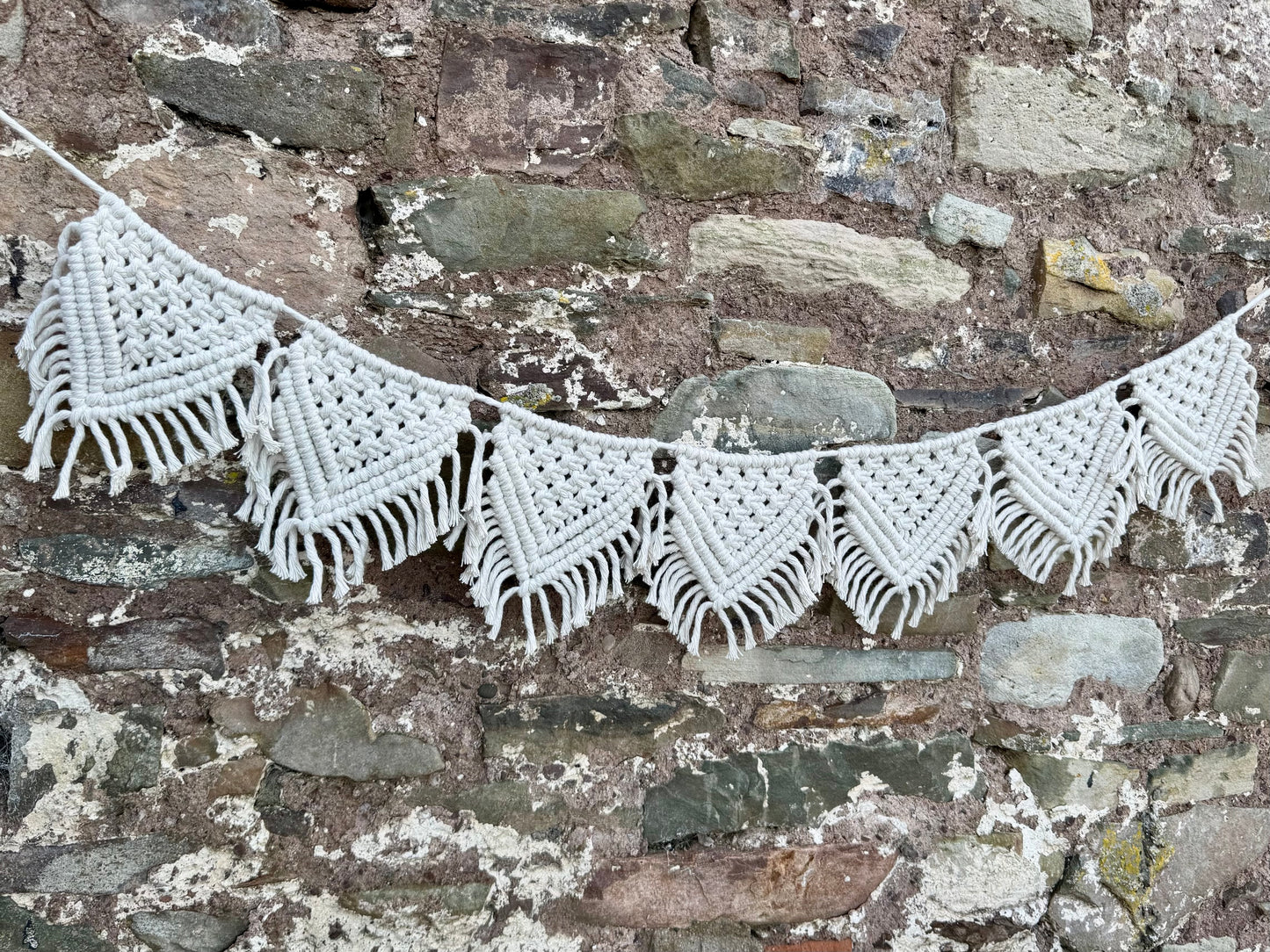 Macrame banner against a stone wall