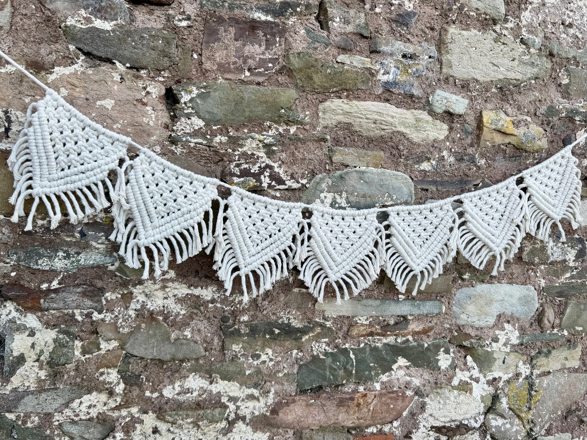 Macrame banner against a stone wall