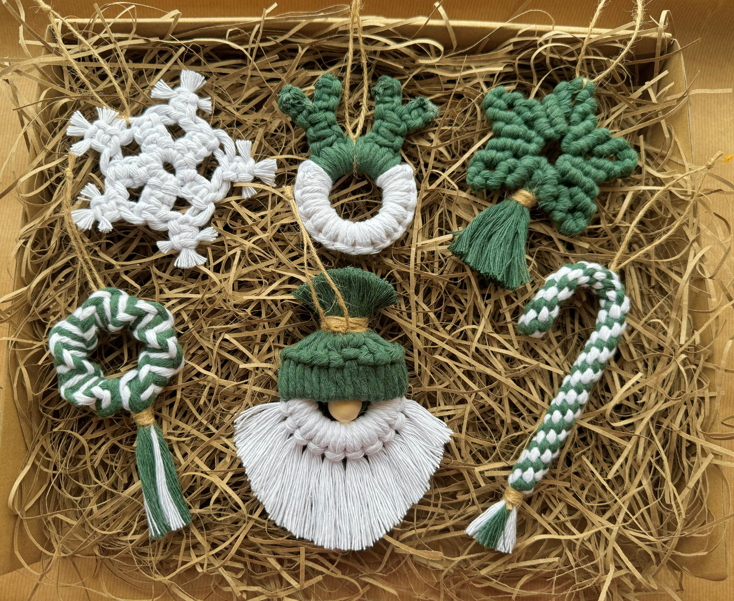 Set of handcrafted Christmas ornaments on straw with a brown box background