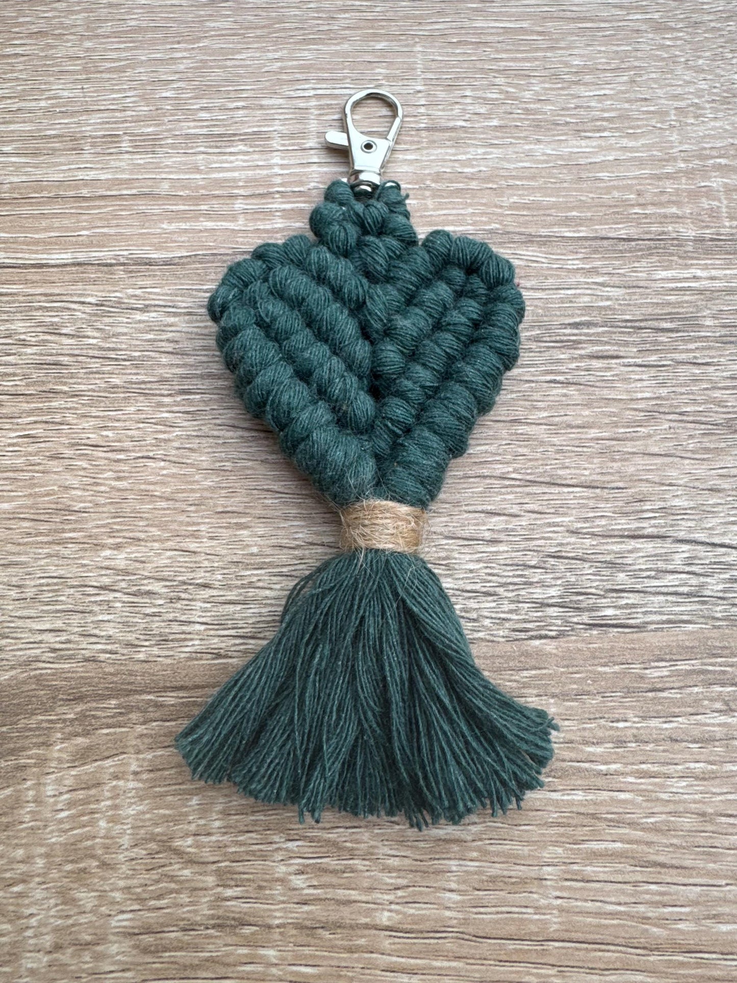 Green knotted keychain with tassel on a wooden surface