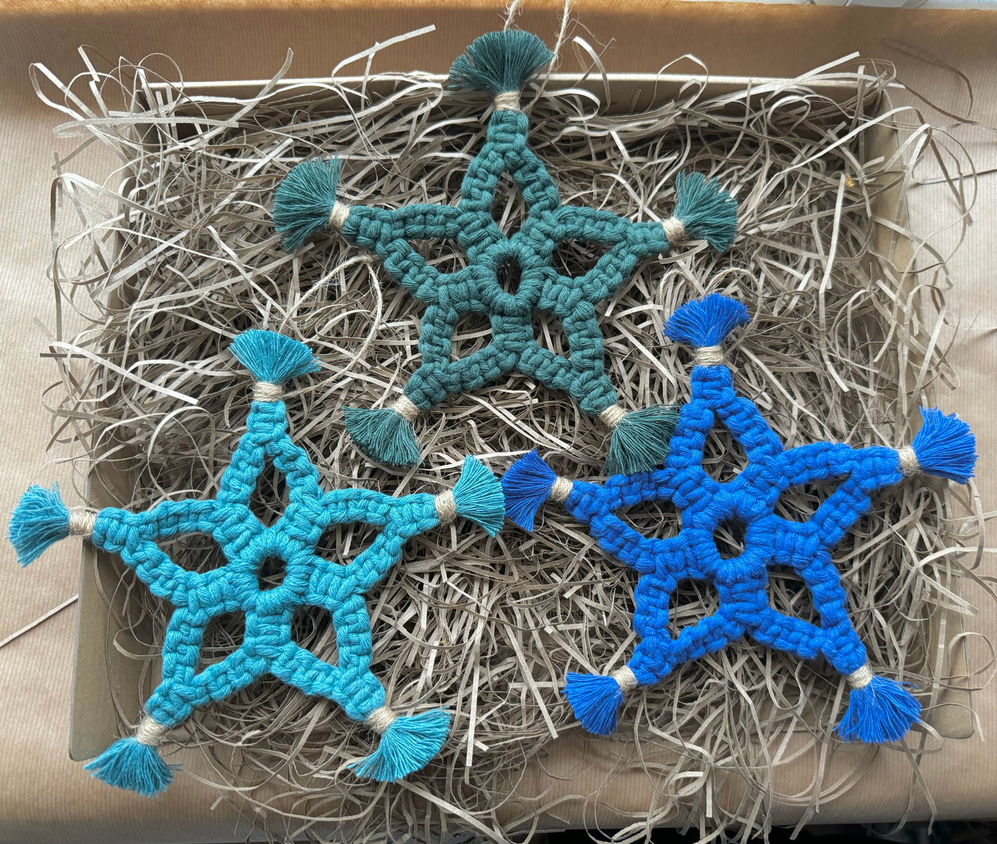 Blue and green star-shaped decorations on a bed of straw.