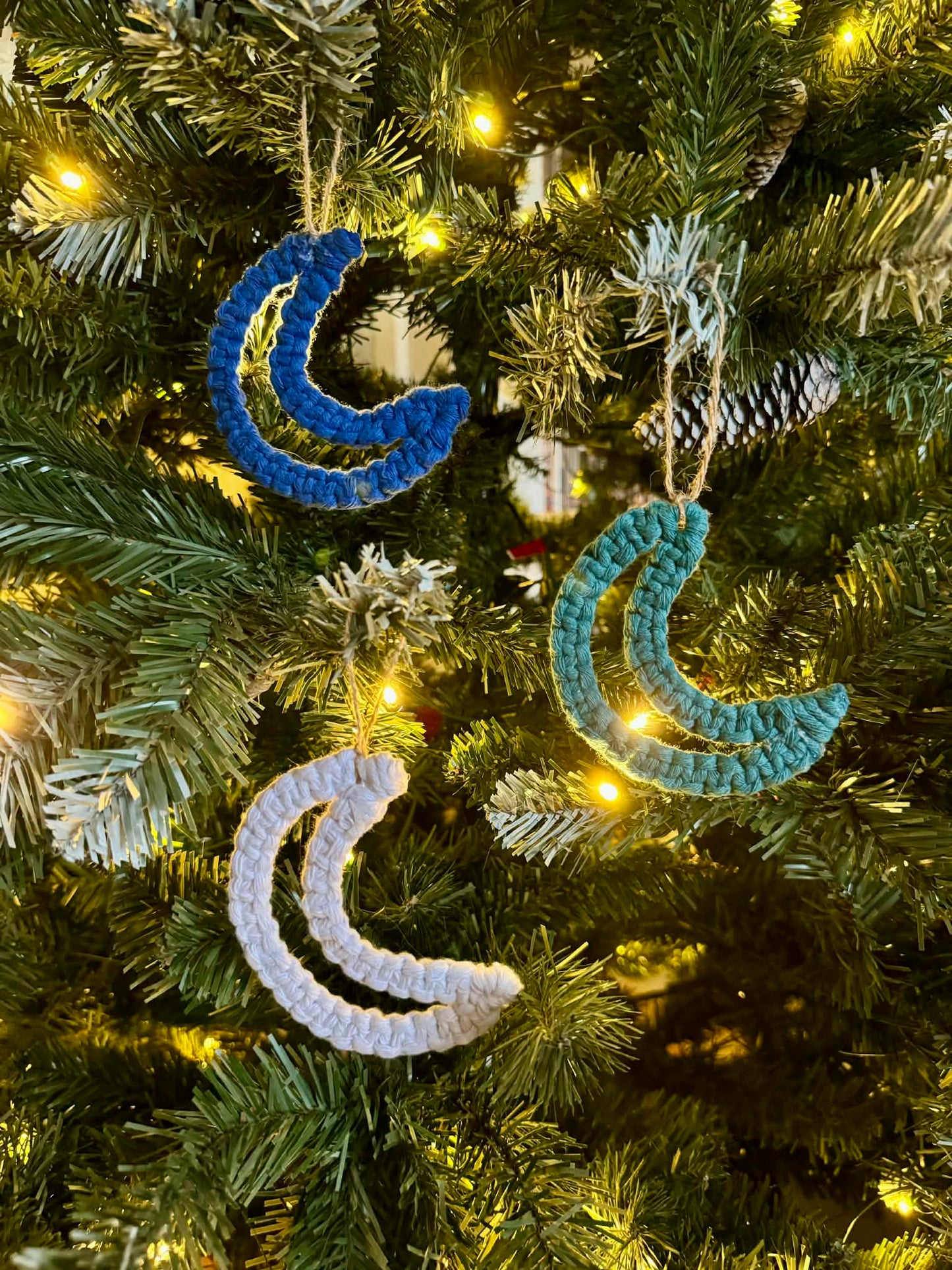 Decorative moon-shaped ornaments on a Christmas tree with lights.