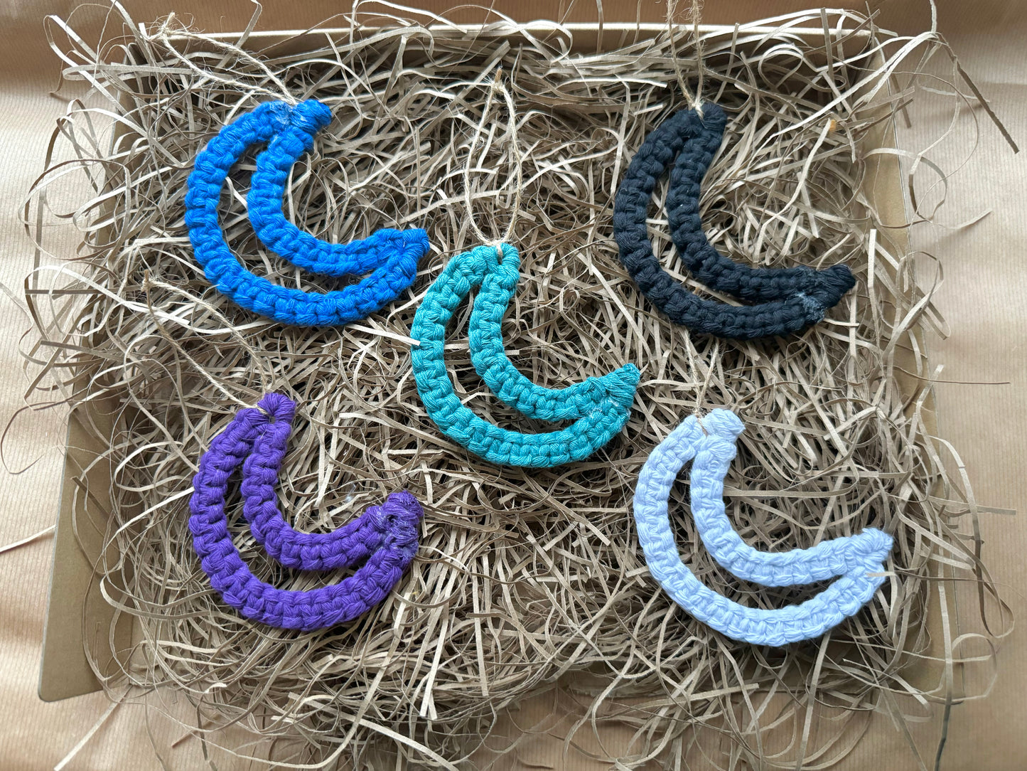Set of colorful crescent moon-shaped decorations on a textured surface