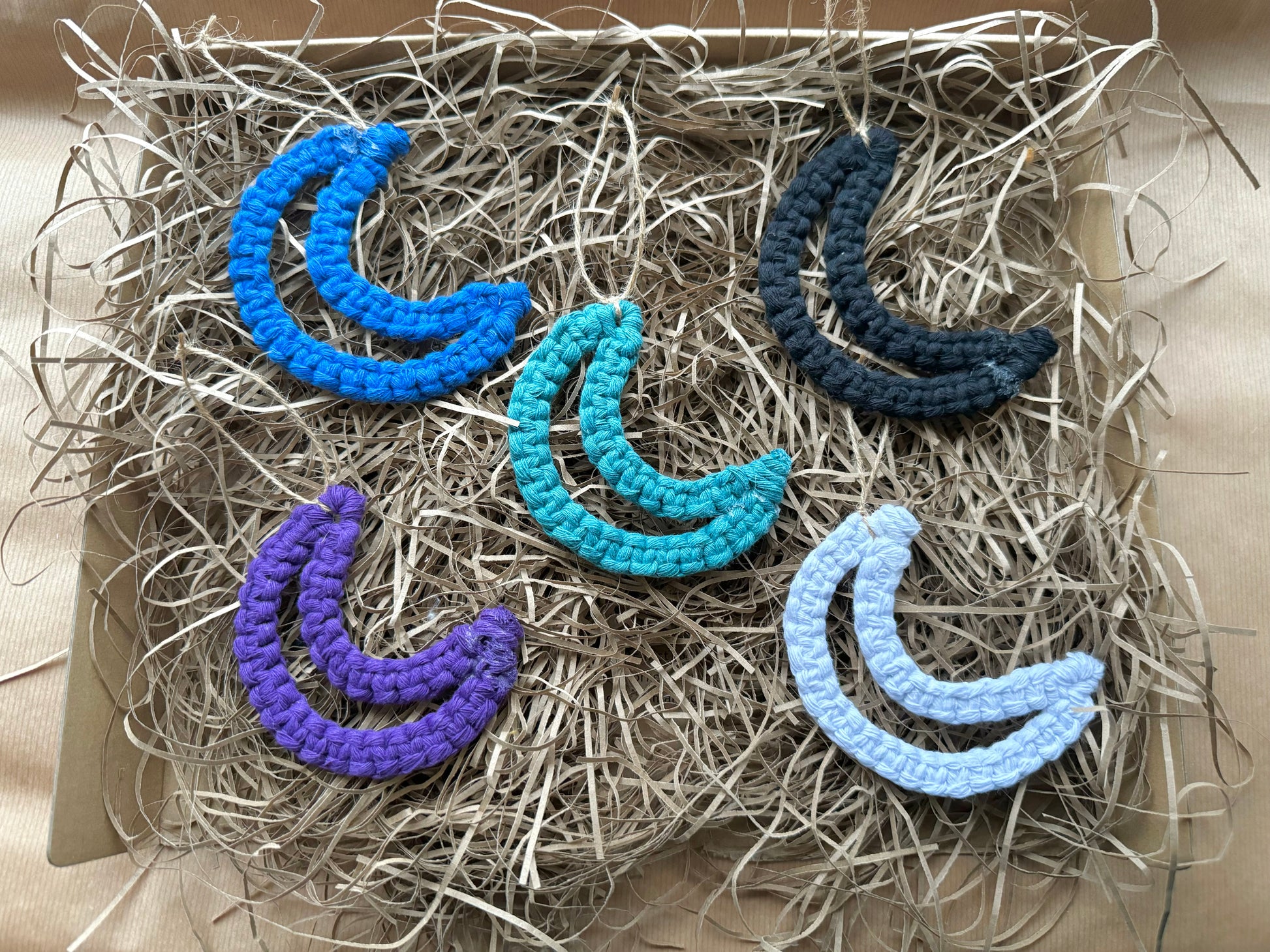 Set of colorful crescent moon-shaped decorations on a textured surface