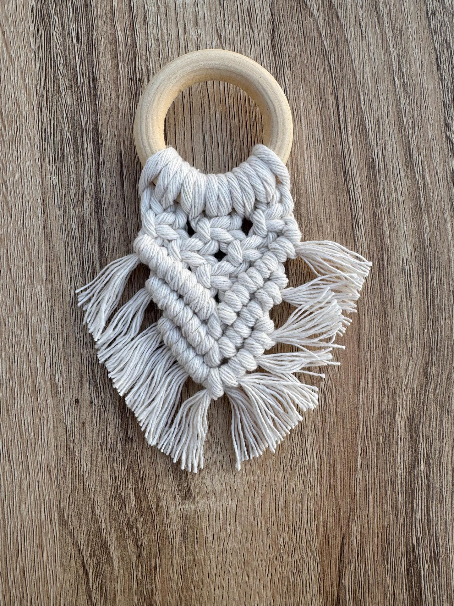 Macrame napkin ring with wooden ring on a wooden surface