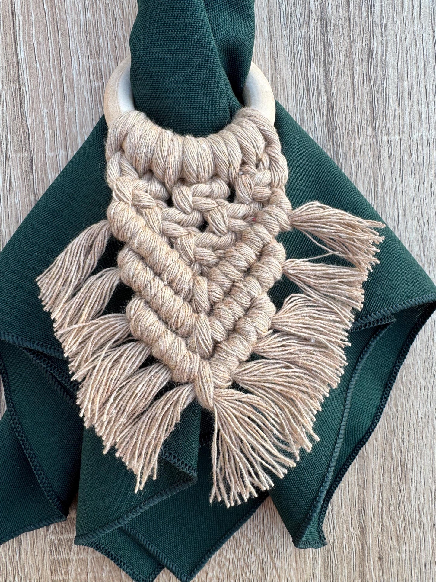 beige macrame napkin ring with a dark green napkin