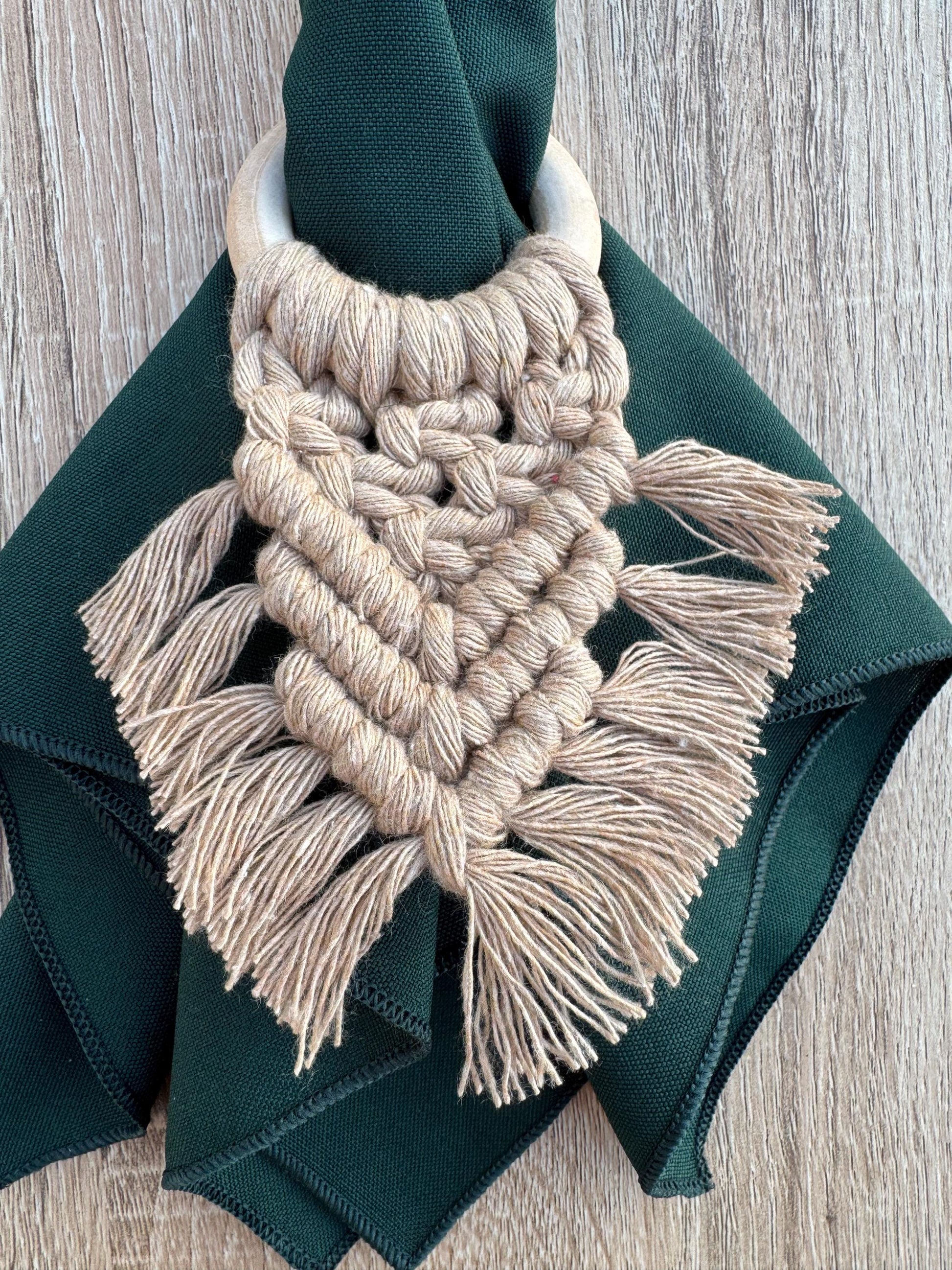 beige macrame napkin ring with a dark green napkin
