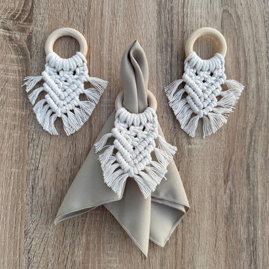 White macrame wooden napkin rings with a napkin on a wooden surface