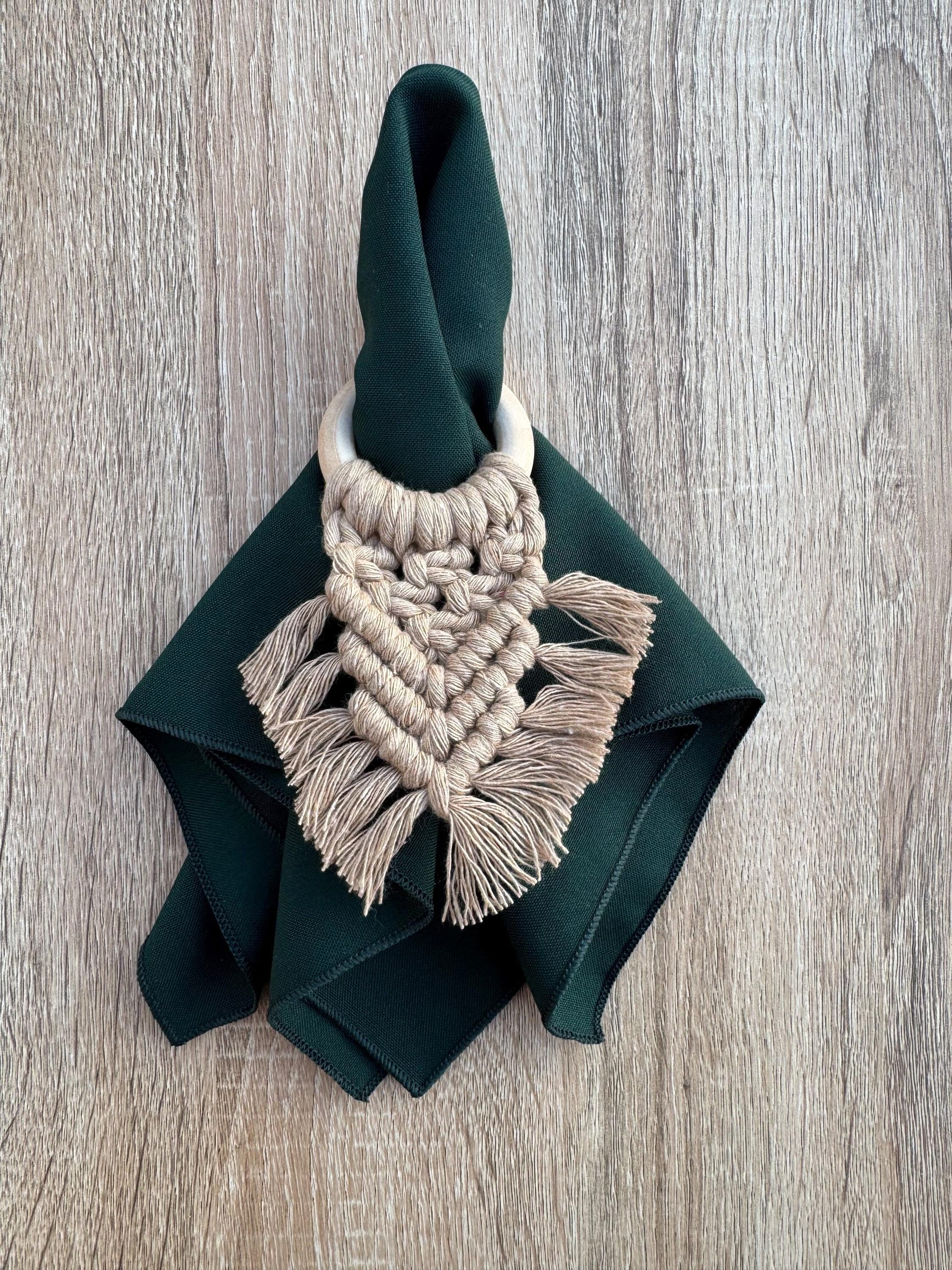 Napkin ring with macrame design on a green napkin against a wooden background