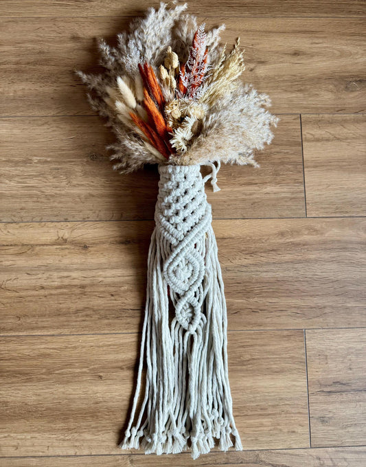 Macrame bridal bouquet wrap with dried flowers on a wooden floor