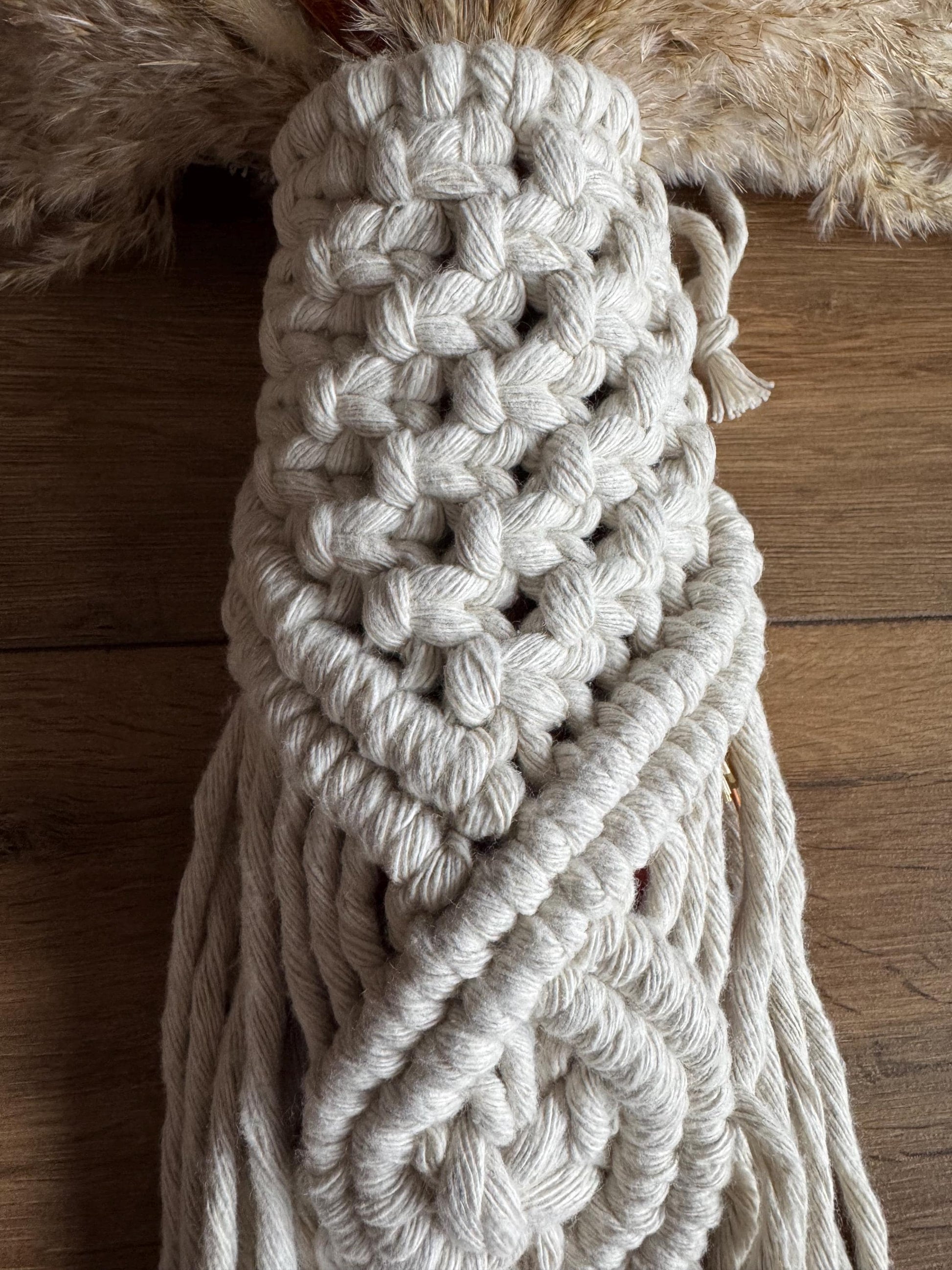 Close-up of macrame knots on a wooden surface