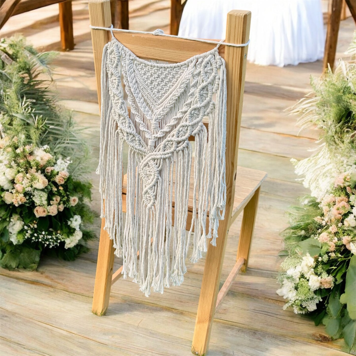 Macrame hanging on the back of a wooden chair with floral decorations on a wooden floor