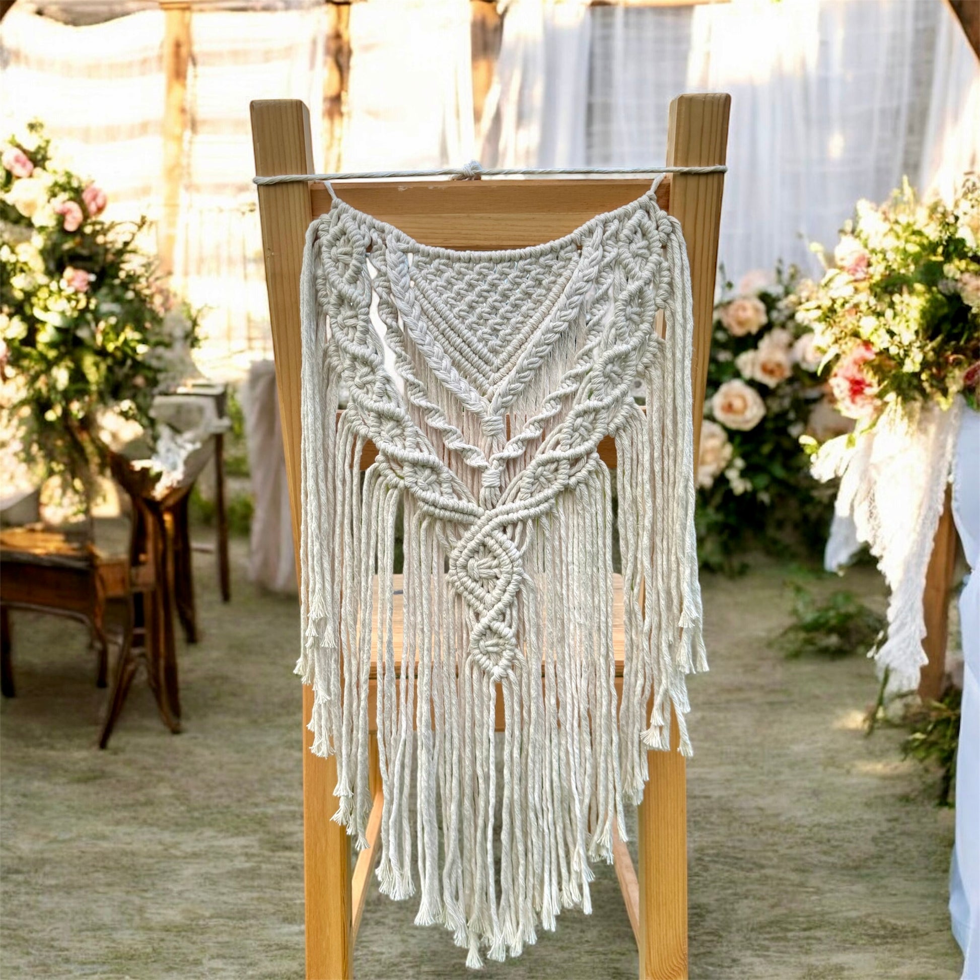 Macrame hanging on a chair with wedding floral decorations and wooden chairs in the background