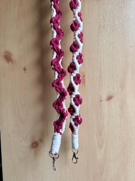 Maroon and white macrame strap on a wooden surface