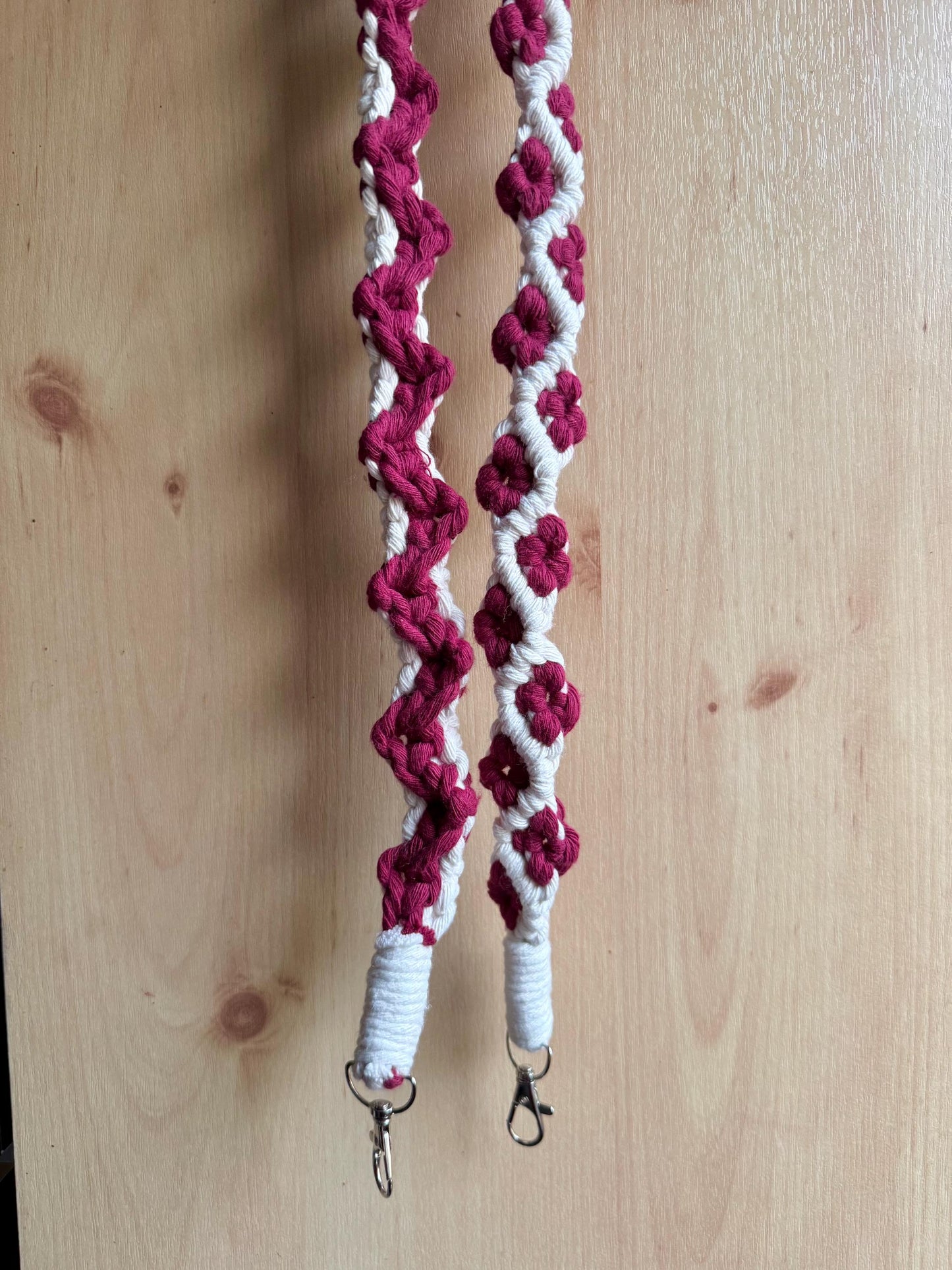 Maroon and white macrame strap on a wooden surface