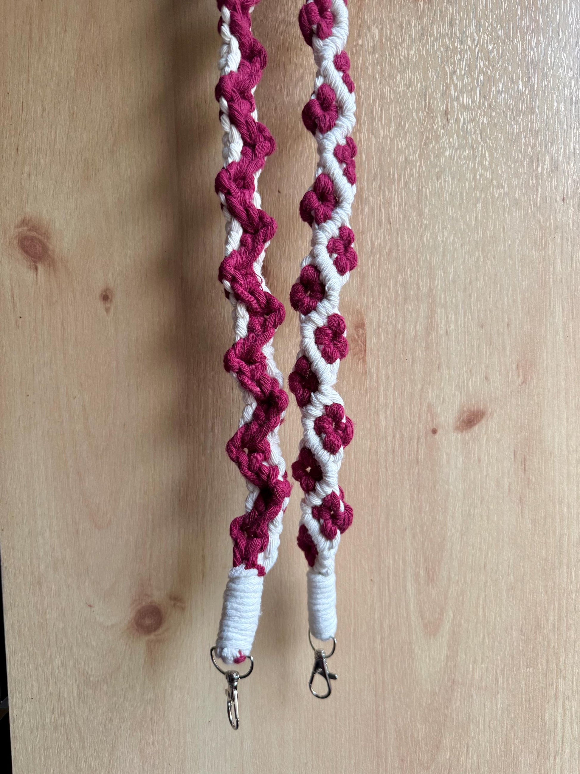Maroon and white macrame strap on a wooden surface
