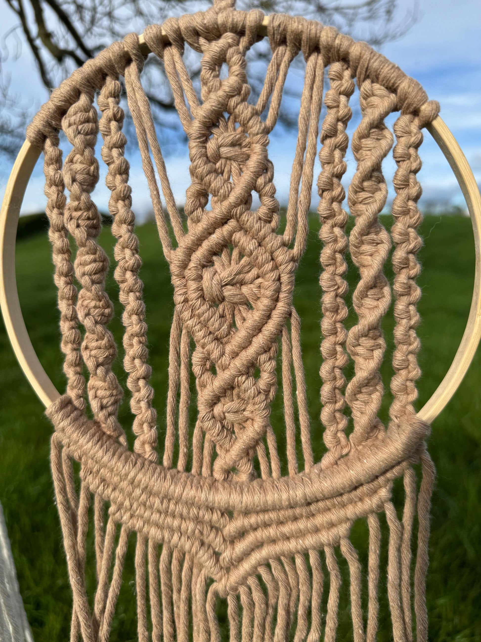 macrame wall hanging within a wooden ring