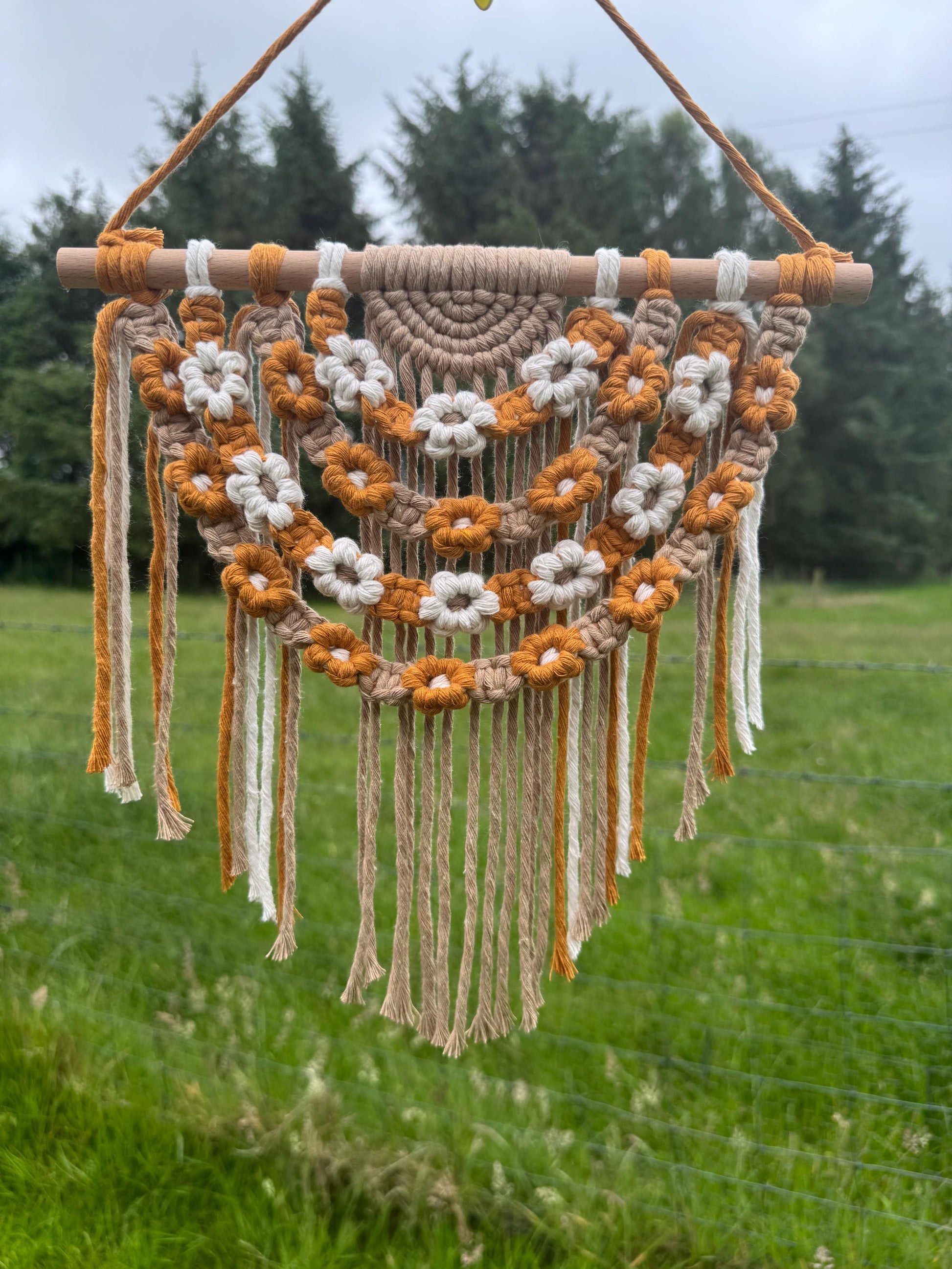 Macrame wall hanging with floral patterns in a natural setting
