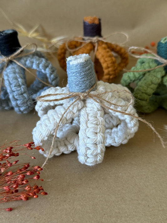 White macrame pumpkin with brown string on a beige background