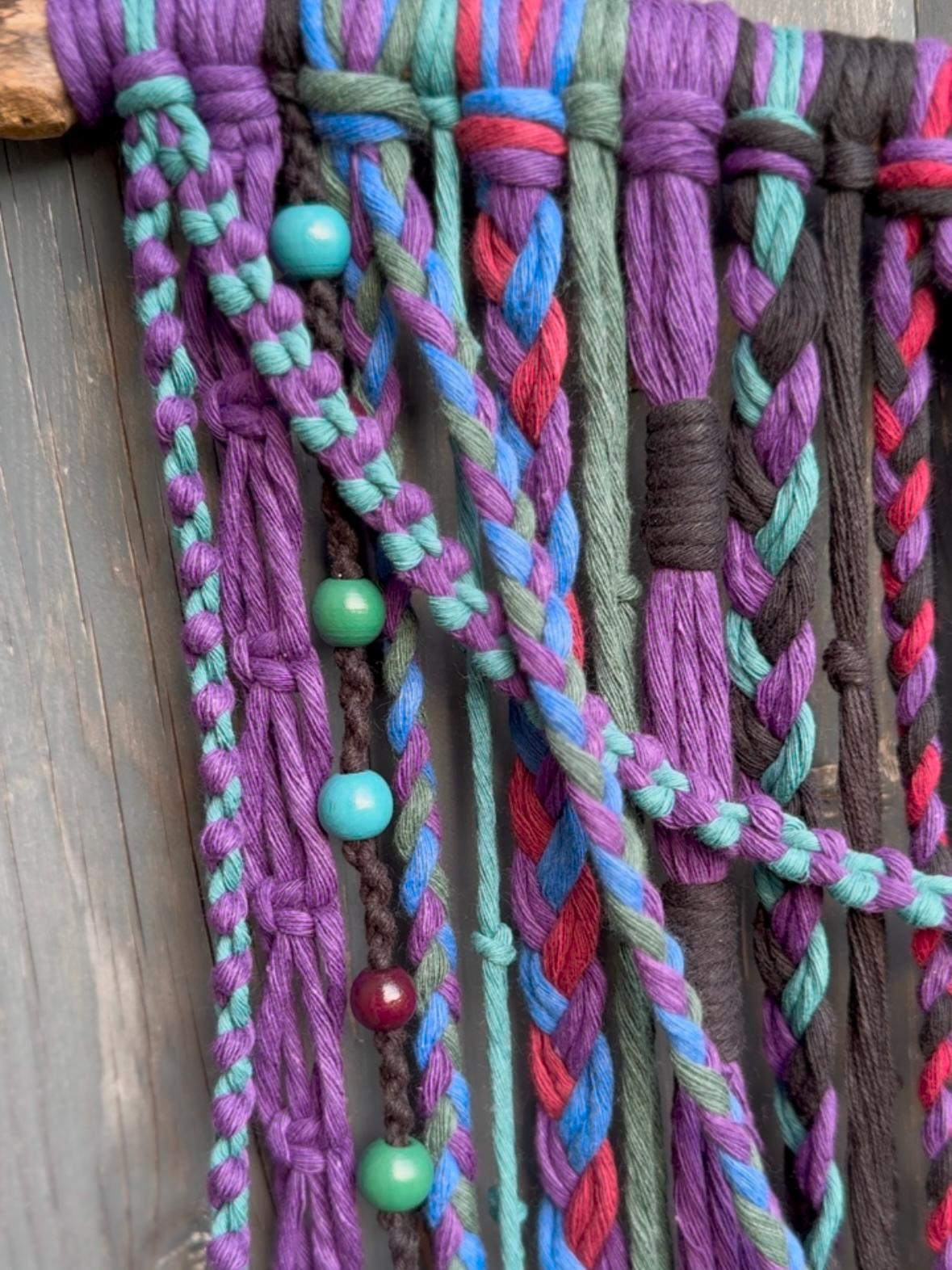 close up of a colourful and beaded macrame wall hanging